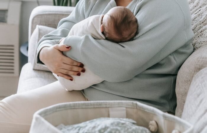 Mother with newborn baby on couch