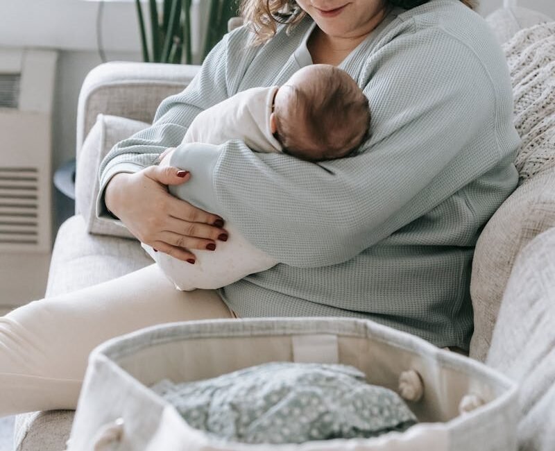 Mother with newborn baby on couch