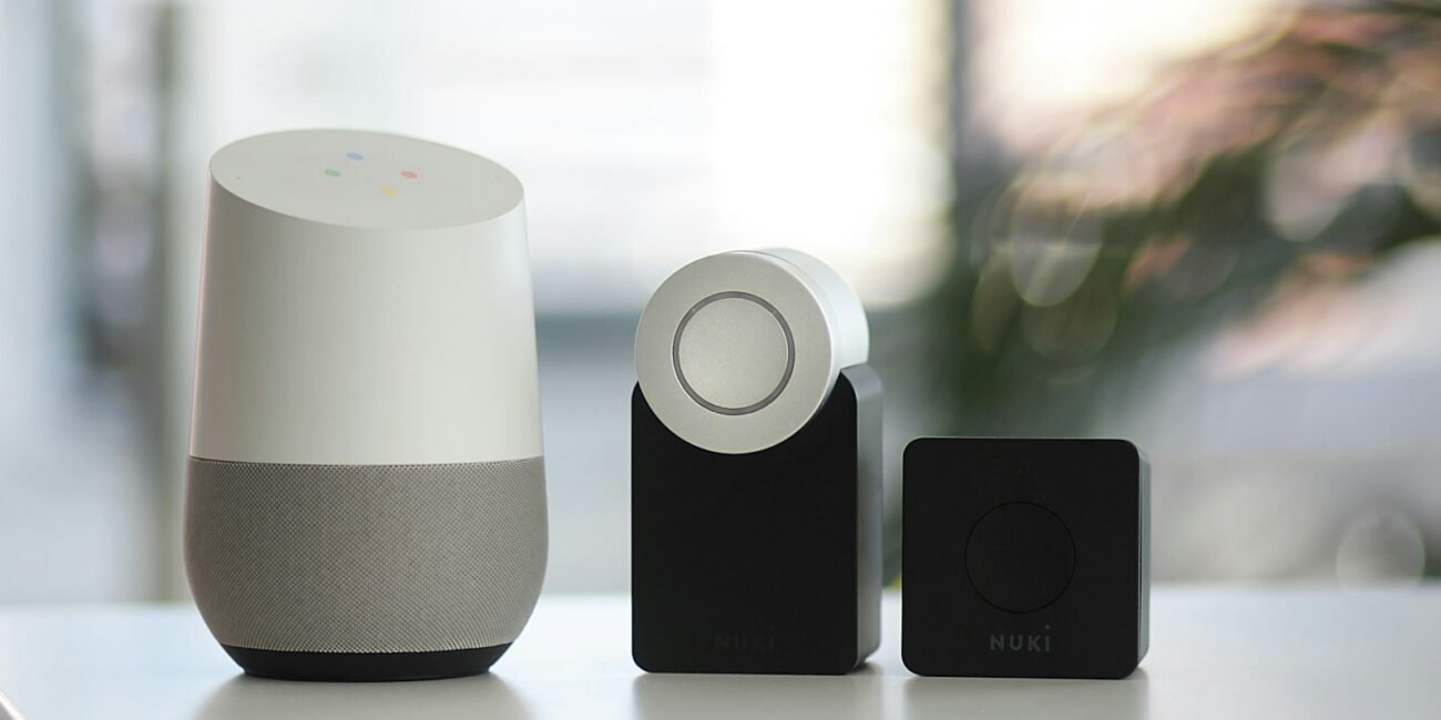 white and gray Google smart speaker and two black speakers