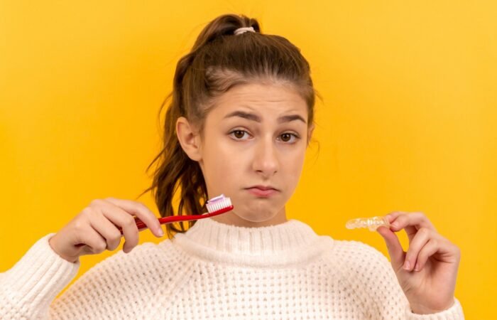 woman in white knit sweater holding red pen