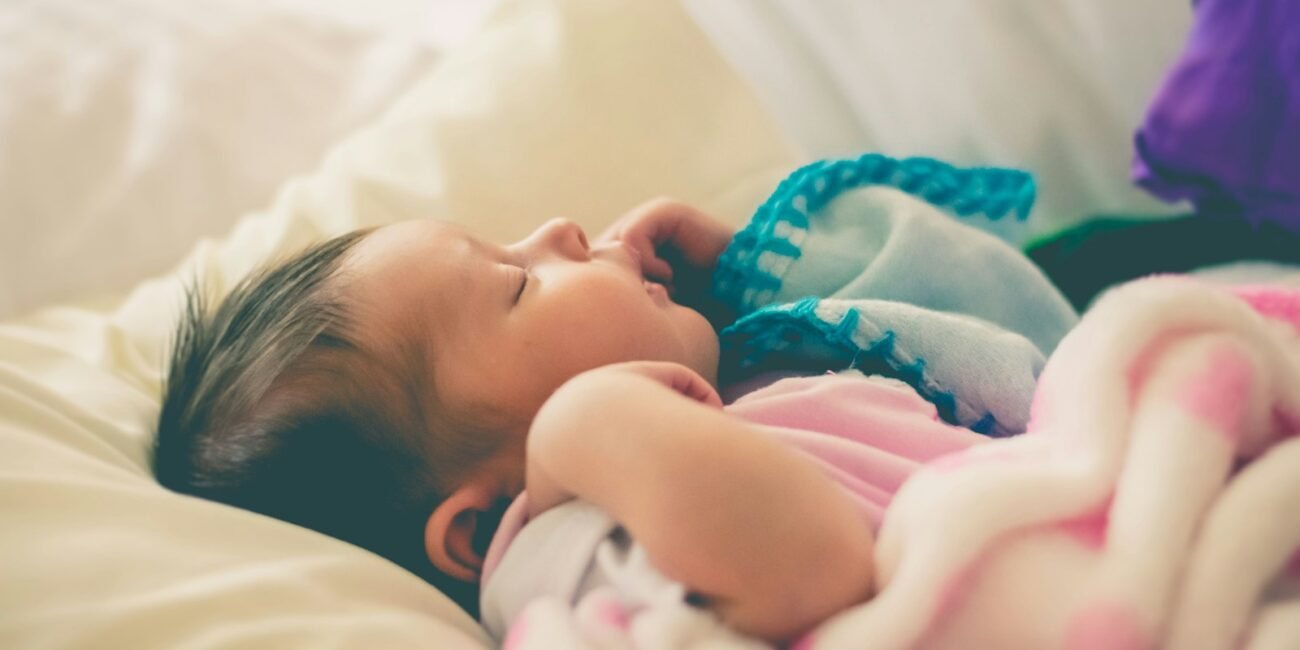 baby sleeping on bed