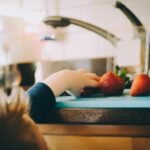 child picking strawberries in kitchen